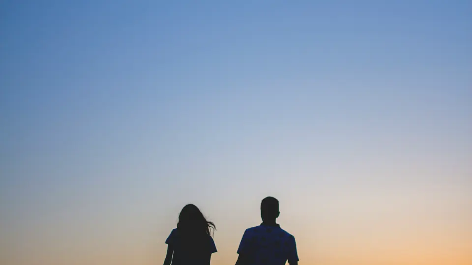 Two adults walking together at sunset