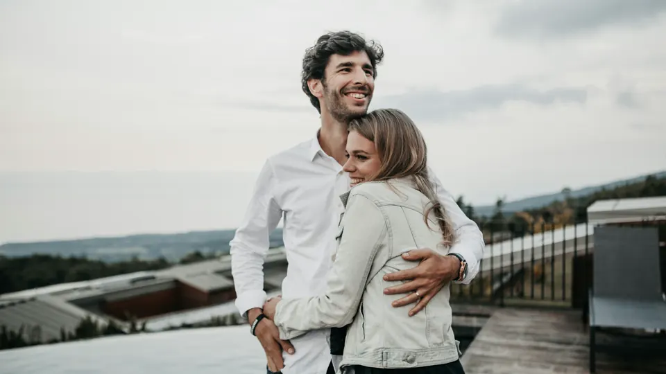 Two adults standing together outdoors